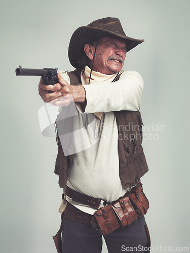Image of Cowboy, senior man and shooting gun, weapon or pistol in studio with costume isolated on a white background. Western, sheriff and mature person with revolver, aiming and scared with fear in Texas