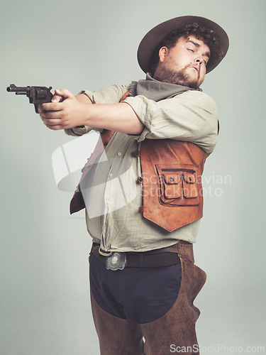 Image of Cowboy, man and shooting gun in studio, weapon and pistol with western costume isolated on white background. Plus size, criminal or funny person with revolver, guess aim or scared with fear in Texas