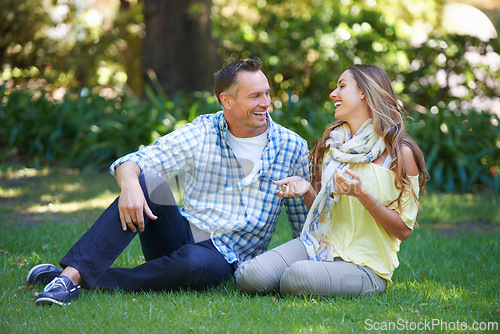 Image of Relax, chat and couple laughing on grass for summer romance, park and fun outdoor date. Love, mature man and happy woman in garden with morning sunshine, conversation and marriage bonding in nature.