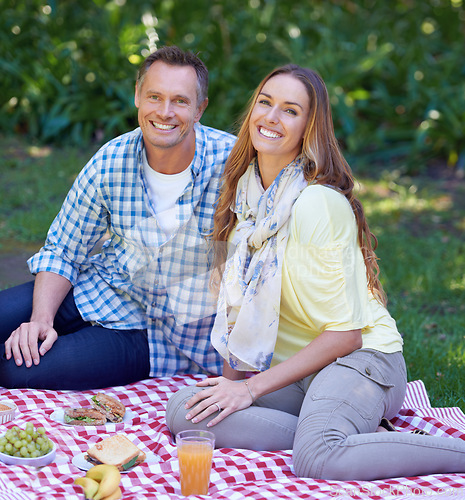 Image of Portrait, picnic and couple with love, smile and happiness with romance and Valentines day with marriage. Outdoor, man or woman on the ground, relationship or anniversary with celebration or vacation