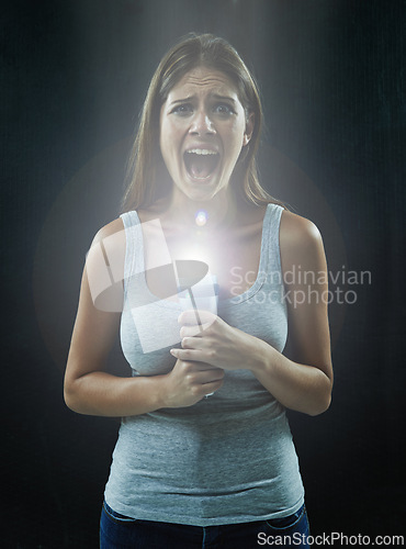 Image of Woman, portrait and scared or flashlight for scream in studio, anxiety and stress for risk in mystery. Female person, shout and lamp in dark against black background, caution and danger or horror
