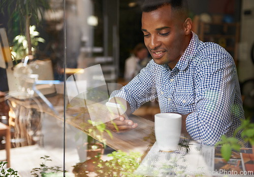 Image of Coffee, window and man with smartphone at cafe for social media, communication and networking. Person, smile and technology in restaurant for texting, message and scrolling on website online