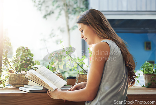 Image of Book, coffee shop and relax with woman reading at table as customer for break, caffeine or literature. Cafe, flare or knowledge and young person at window in restaurant with novel or story on weekend