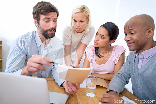 Image of Team, notebook and business people listening to leader, brainstorming or mentor training interns in startup. Group, coaching and employees in collaboration, planning or creative designers in meeting