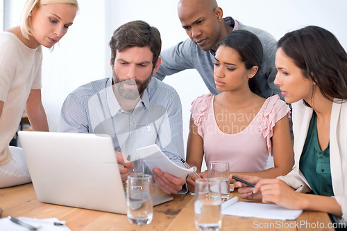 Image of Team, laptop and business people problem solving, planning or brainstorming ideas in startup office. Group, computer or serious employees in collaboration, strategy or creative copywriters in meeting