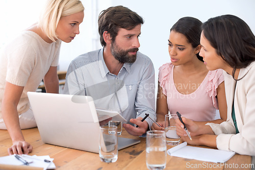 Image of Group, laptop and business people in discussion, planning or brainstorming on notebook in startup. Team, computer and serious employees in collaboration, strategy or creative copywriter in meeting
