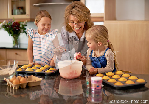 Image of Grandma, children and smile for teaching, baking and decorating for family, play and bonding at home. Happy, pensioner and girl with cupcake, laugh and icing for creative fun together in kitchen