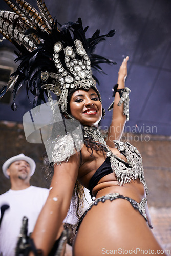 Image of Dancer, carnival and girl in portrait with confidence, pride or culture in low angle for music performance in night. Person, woman and stage at event, party and smile at celebration in Rio de Janeiro