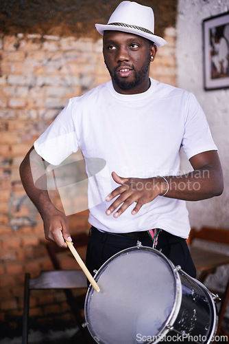 Image of Performance, drum or carnival with a black man playing an instrument in a festival in Rio de Janeiro. Brazil, rhythm or party with a musician, performer or artist banging to create a beat in show