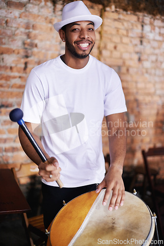 Image of Portrait, drum or carnival with a happy man playing an instrument in a festival in Rio de Janeiro. Brazil, smile or party with a proud musician, performer or artist banging to create a beat or rhythm