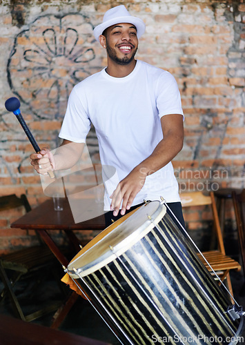Image of Music, drums or carnival with a happy man playing an instrument in a festival in Rio de Janeiro. Brazil, smile or party with a male musician, performer or artist banging on a drum to create a beat