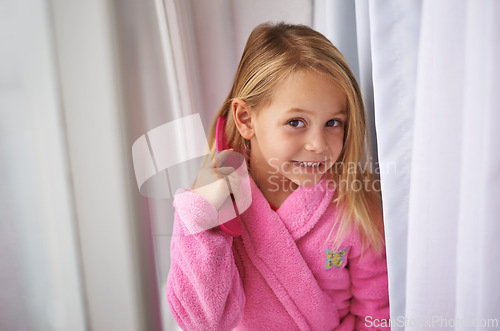 Image of Child, hair and brush or portrait for morning routine in bathrobe for grooming getting ready, treatment or cosmetic. Girl, kid and comb in home apartment in London for style care, healthy or texture