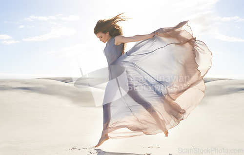 Image of Desert, woman and fashion with dress, jumping and relaxing with confidence and getaway trip. Person, outdoor and sand with girl and clouds with fabric, fun and summer with weekend break and active