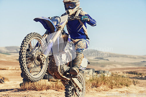 Image of Motorbike, action and balance, person with speed and skill for adrenaline and stunt with extreme sports outdoor. Competition, adventure and power with risk, biker riding on motorcycle with wheelie