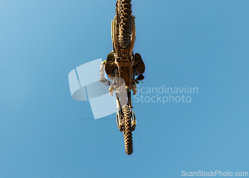 Image of Motorcycle, jump and person on blue sky mockup with low angle for performance, extreme sports stunt and adrenaline. Competition, fearless and man on motorbike for outdoor challenge and skill.