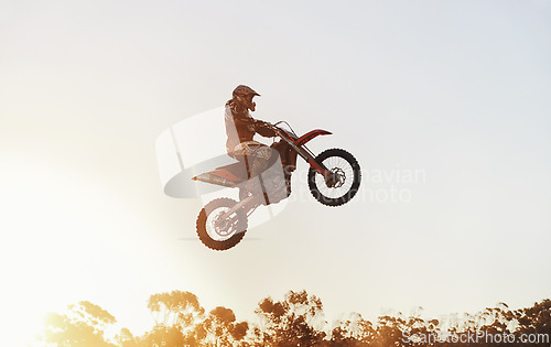 Image of Person, jump and motorcyclist in the air with sunset on mockup for trick, stunt or ramp on outdoor dirt track. Expert rider on motorbike with lift off for extreme sports or rally challenge in nature