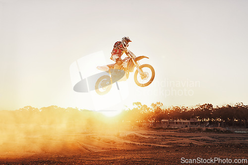 Image of Person, jump and motorcyclist with sunset for trick, stunt or ramp on mockup or outdoor dirt track. Expert rider on motorbike in the air with lift off for extreme sports or rally challenge in nature