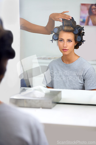 Image of Beauty, hair curlers and woman in mirror of salon with .professional stylist for makeover. Haircare, face reflection or curling and celebrity or actress getting ready backstage behind the scenes