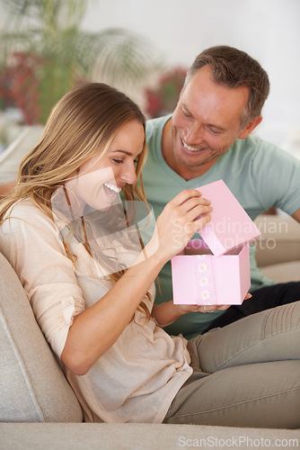 Image of Woman opening present, man and happiness with surprise for birthday or anniversary, love and support with romance. Couple in marriage, unboxing package and gift giving for token of appreciation
