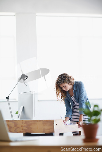 Image of Business, woman and writing or planning at office desk for creative, project and startup on desktop or computer. A young worker or graphic designer with notes for website brainstorming and research