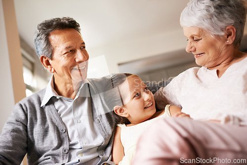 Image of Home, smile and grandparents with grandchild in living room, together and love with happiness. Old people, grandmother and grandpa in house as seniors in retirement, elderly and bonding with girl