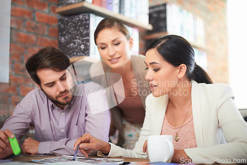 Image of Team, paperwork and business people in discussion, planning or designers brainstorming ideas for media in startup. Collaboration, employees and creative group in conversation for office in meeting