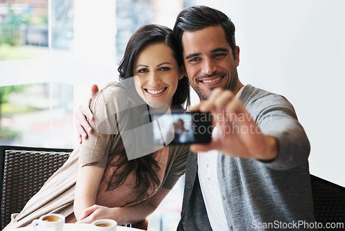 Image of Couple, smile and date at cafe taking selfie for posting, blog or happy in restaurant with coffee, tea or latte. People, bonding or love together for pictures for social media, online or indoors