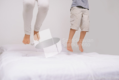 Image of Jumping, bed and kids with legs, energy and morning in a bedroom with game and feet. Youth, sibling and home with a excited child on duvet in air with crazy play, leap and fun in house with friends