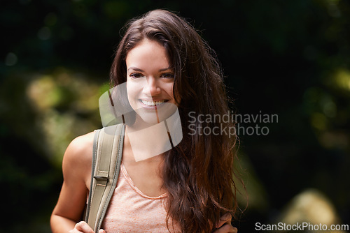 Image of Walking, travel or happy woman in nature, woods or wilderness for trekking or outdoor adventure with bag. Smile, relax or hiker hiking in natural park or forest for exercise or wellness on holiday