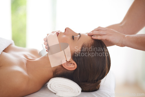 Image of Spa, massage and hands on head of woman to relax on table for skin care, treatment or facial. Calm, person and girl in salon or resort on holiday or vacation with wellness and healthy stress relief