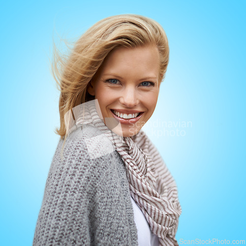 Image of Autumn, fashion and portrait of happy woman in studio, blue background or mock up space. Casual, style and girl with beauty from makeup, cosmetics or positive attitude in cardigan, jersey and scarf