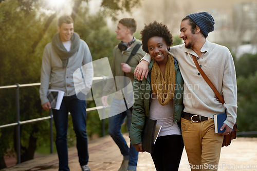 Image of Interracial, couple and college student with hug in outdoor, campus and happy with love, support and care. University, education and texbook with notes for research to study for exams and assessment