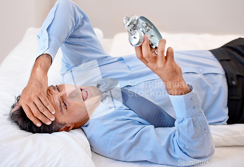 Image of Businessman, alarm clock and stress for waking up in bed, anxiety and late for business. Male person, frustrated and annoyed for time at home, professional and sleepless or lazy and worry in bedroom