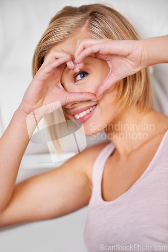Image of Portrait, woman and hand with heart on eye for vision, motivation or kindness with support emoji. Smile, person and happiness with love symbol for hope, care sign and trust gesture for wellness