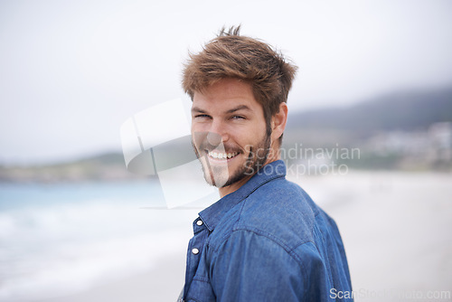 Image of Happy, portrait and beach with man on summer vacation, getaway trip and adventure. Ocean, smile and male person for happiness, wellness and travel destination for peace, weekend break and tourism.