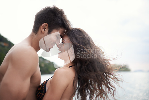 Image of Couple, forehead touch and travel to ocean on vacation, love and relax by water on holiday. People, swimwear and bonding for relationship in outdoors, support and smile on trip to sea or nature