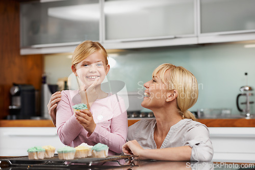 Image of Happy, mom and child with cupcake in kitchen and portrait of baking together in home to relax. Family, bonding and kid smile with mother, excited for eating cake, sweets or enjoy food in house