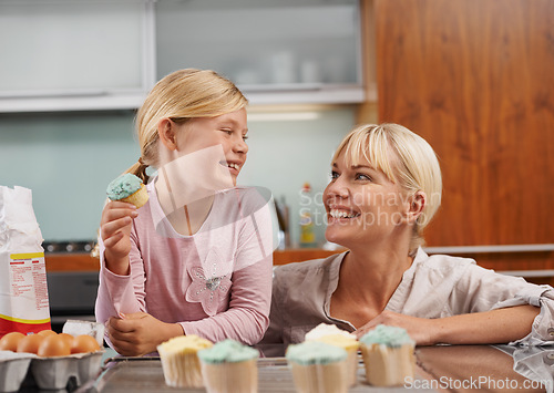 Image of Happy, mom and child with cupcake in kitchen and learning about baking together in home to relax. Family, bonding and kid smile with mother, excited for eating cake, sweets or enjoy food in house