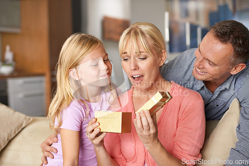 Image of Surprise, father and child with present for mom on birthday or opening a box on mothers day. Family, gift and dad with kid in home giving woman unique package of gold to show gratitude, care or love