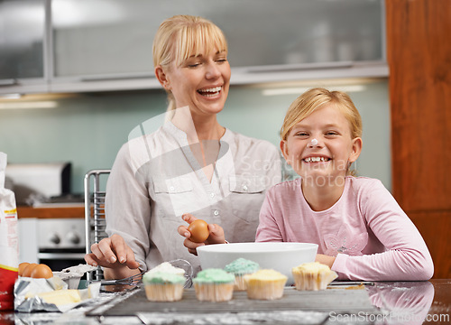 Image of Baking, cupcake and portrait with child and mom in kitchen to relax in home together on holiday. Family, bonding and kid smile with frosting on face and mother laughing and enjoy food prep in house