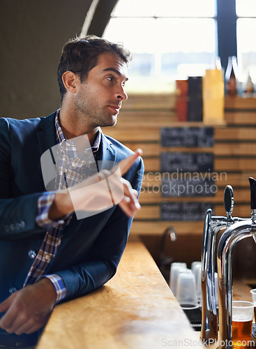 Image of Businessman, counter and order drink in pub after long day at work, relax and hospitality industry. Male person, buying and beer for enjoyment after job for happy hour, table and hand sign for waiter