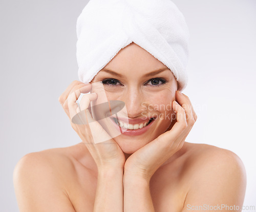 Image of Studio, happy woman and portrait with hair in towel and skincare in spa facial with cosmetology. Young model, smile and face for dermatology with clean shower and body treatment by white background