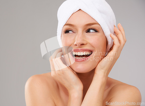 Image of Happy, woman and thinking about skincare for beauty and healthy dermatology in studio background. Girl, smile and model laughing with glow on skin from facial, cosmetics or towel for self care