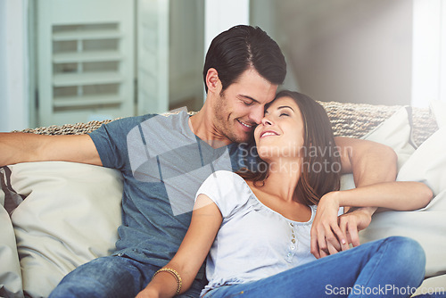 Image of Love, smile and couple relaxing on sofa by patio cuddling and bonding for marriage at home. Happy, romance and young man and woman resting together on couch by outdoor porch of modern house.