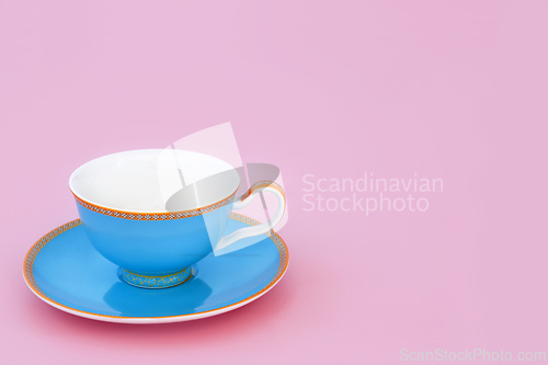 Image of Blue and Gold Porcelain Tea Cup on Pink Background