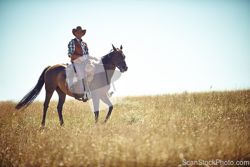 Image of Man, horse and countryside land as cowboy for adventure riding in Texas meadow for explore farm, exercise or training. Male person, animal and stallion in rural environment on saddle, ranch or hobby