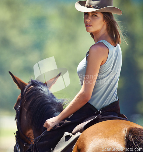 Image of Woman, countryside and portrait of cowgirl with horse for ride, journey or outdoor adventure in nature. Face of female person or western rider with hat, saddle and animal stallion at ranch or farm