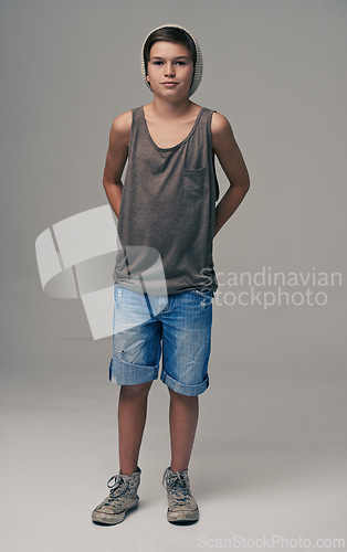 Image of Young boy, portrait and fashion with denim shorts or jeans for style on a gray studio background. Male person, child or teenager with summer clothing or cool stylish outfit with beanie on mockup