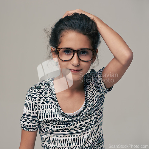 Image of Portrait, fashion and glasses with girl child in studio isolated on gray background for optometry style. Kids, frame lens or eyewear with cute young geek or nerd in clothes outfit and accessories
