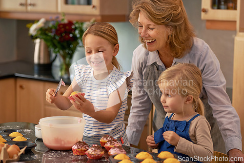 Image of Mature woman, children and smile for baking in retirement for family, fun and bonding at home. Happy, female pensioner and girl with cupcake, laugh and icing for creative fun together in kitchen